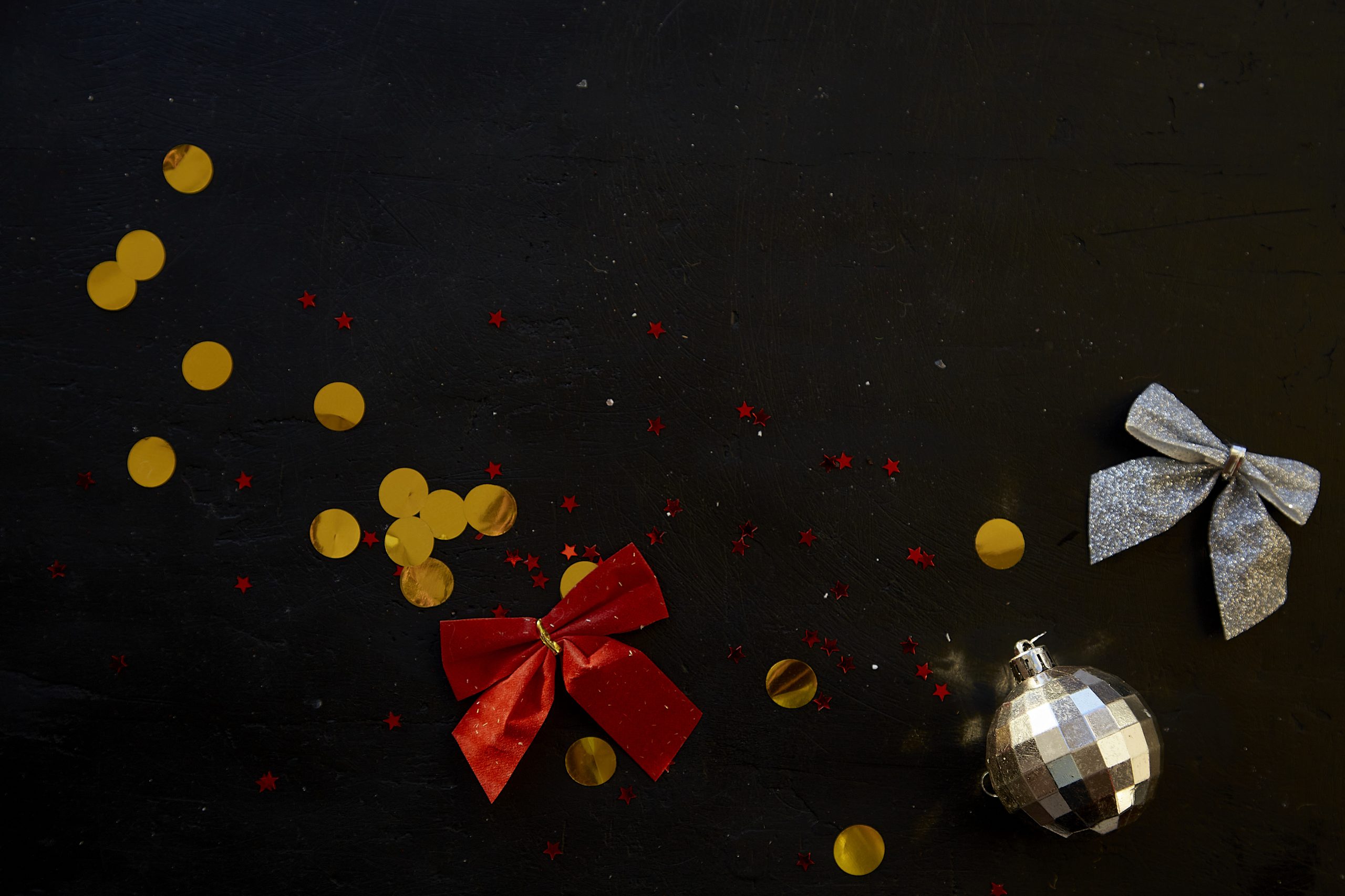 Aesthetic Christmas black background decorations - festive disco ball and golden glitter.